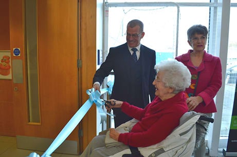 CEO Brian Carlin, Mary Tye cutting the ribbon and her daughter Leo